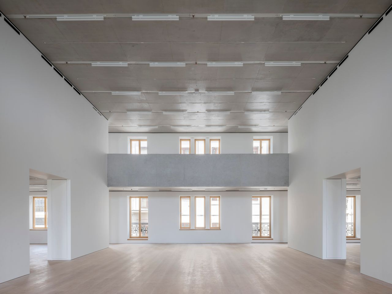 Vista simétrica de la sala de doble altura y pasarela interior en la rehabilitación del Edificio Pereda por David Chipperfield.