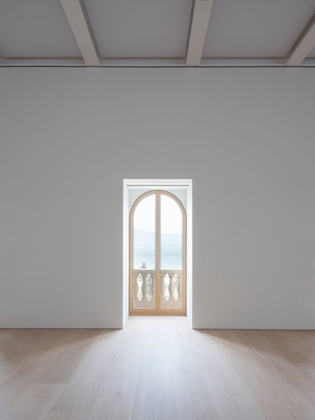Ventanal de medio punto con balustrada y vistas a la bahía en las salas de Faro Santander.