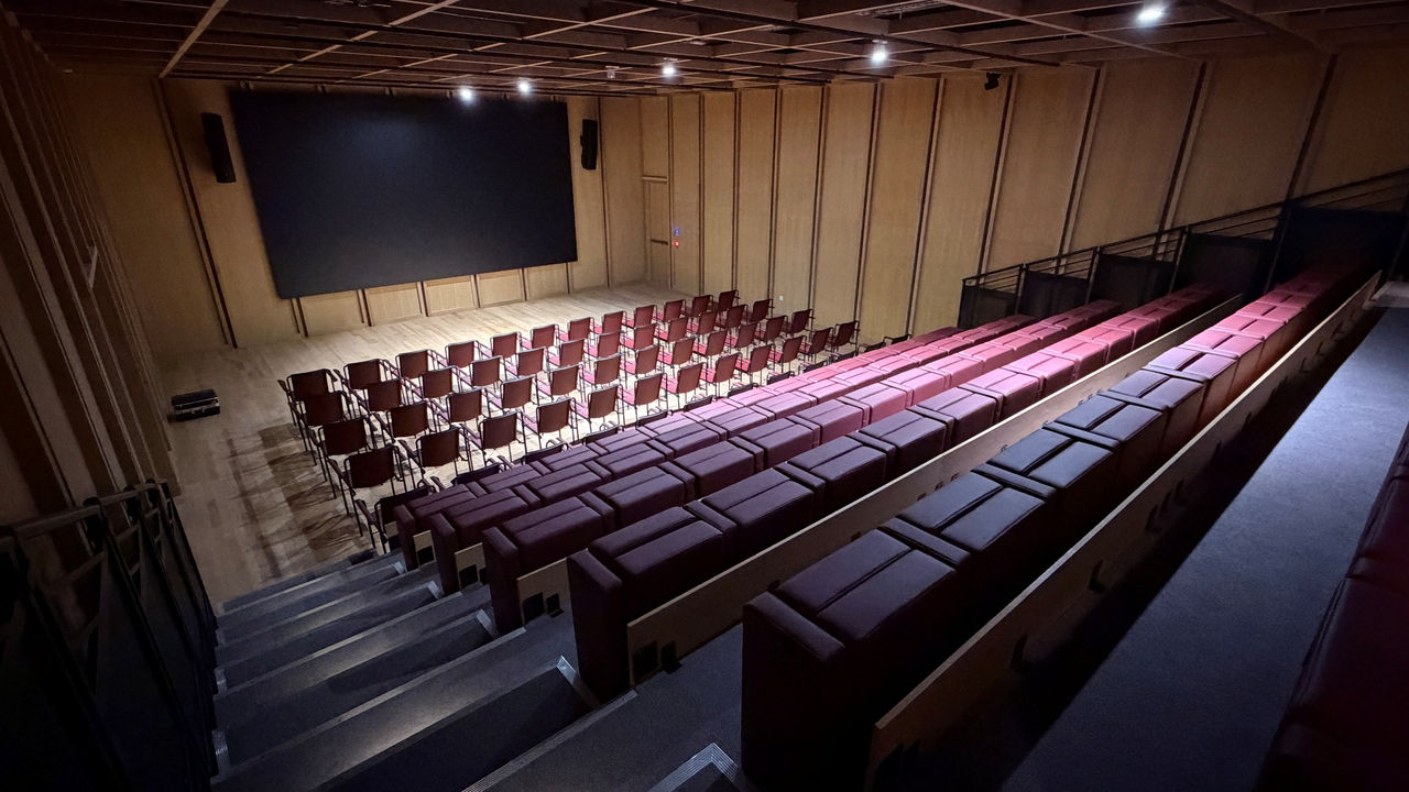 Vista desde la grada superior del Auditorio de Faro Santander mostrando la pantalla principal para proyecciones y conferencias.